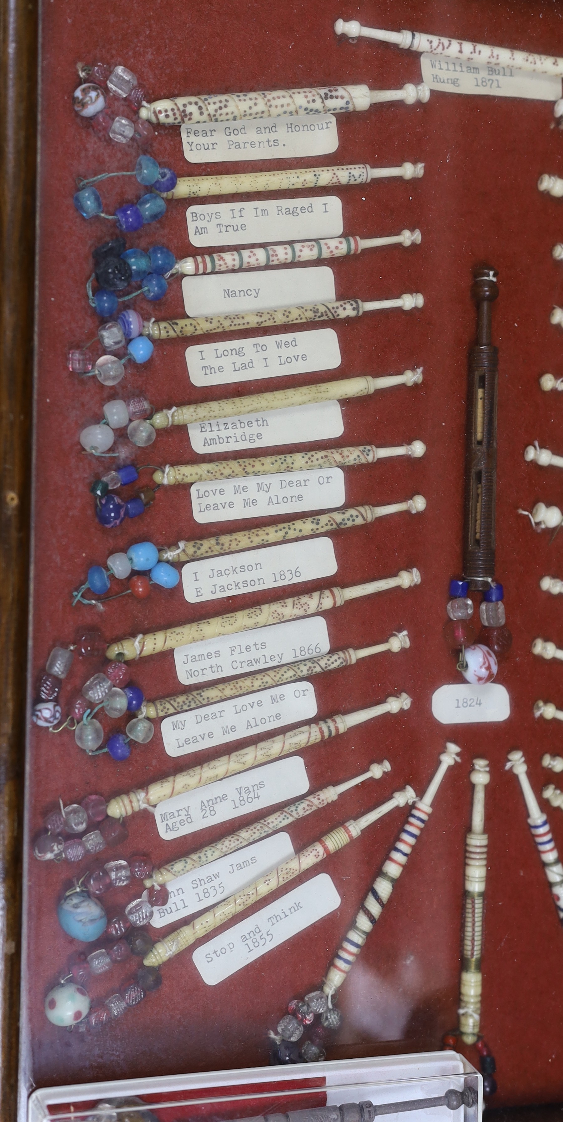 A cased collection of 19th century inscribed bone and glass bead lace bobbins, some dated and named